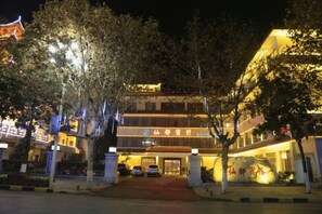 A hotel entrance with a traditional architectural style, a well-lit facade, and a welcoming entrance. - Xiandu Hotel (Danjiangkou)
