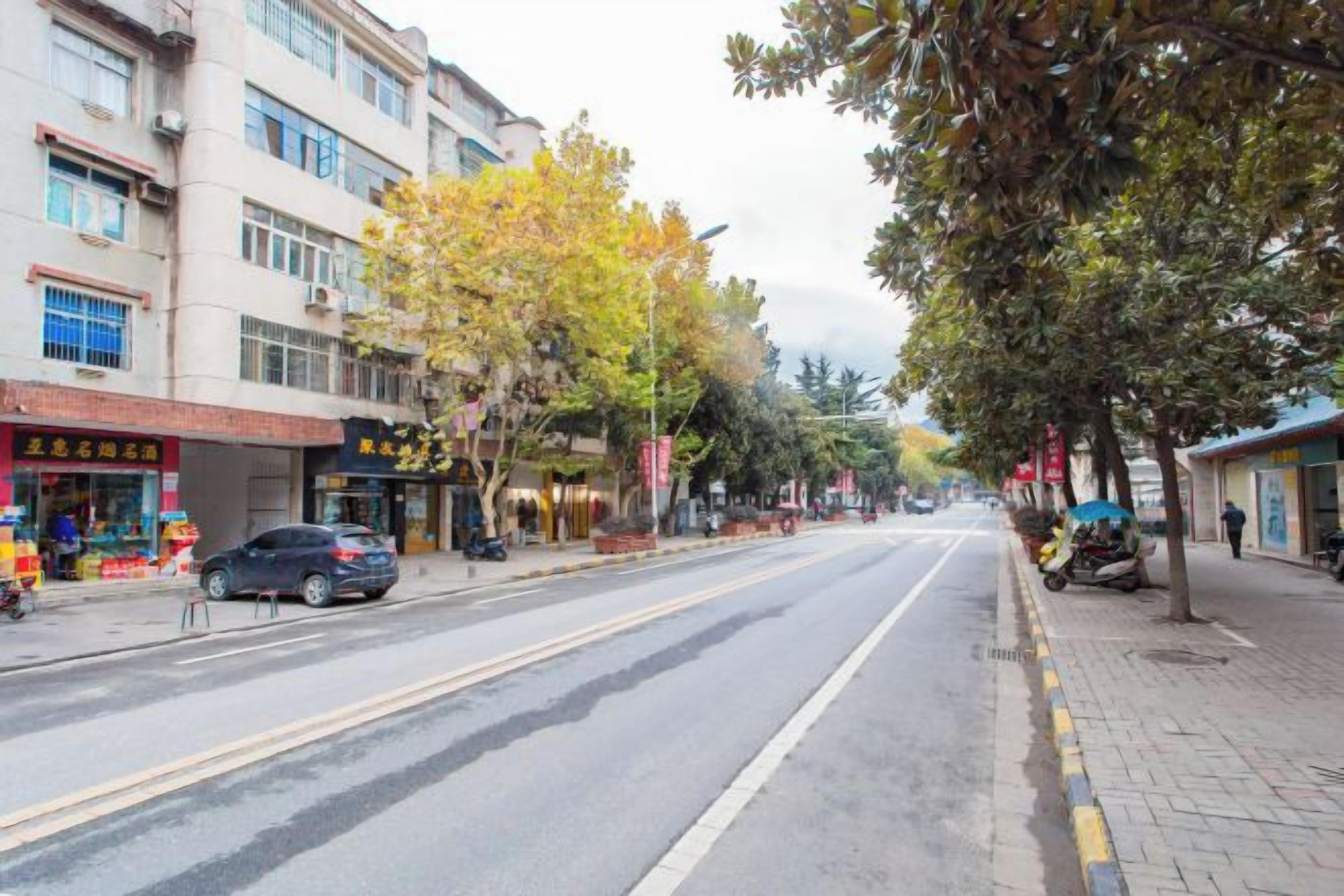 Una calle con edificios, árboles y cielo despejado.