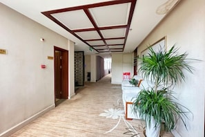 A hotel corridor with a reception desk, a reception area, and a door on the left. - Xiandu Hotel (Danjiangkou)