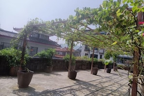 A courtyard with potted plants and a pergola structure. - Xiandu Hotel (Danjiangkou)