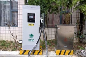 A utility meter box with a digital display and warning labels, situated outdoors with a building in the background. - Xiandu Hotel (Danjiangkou)