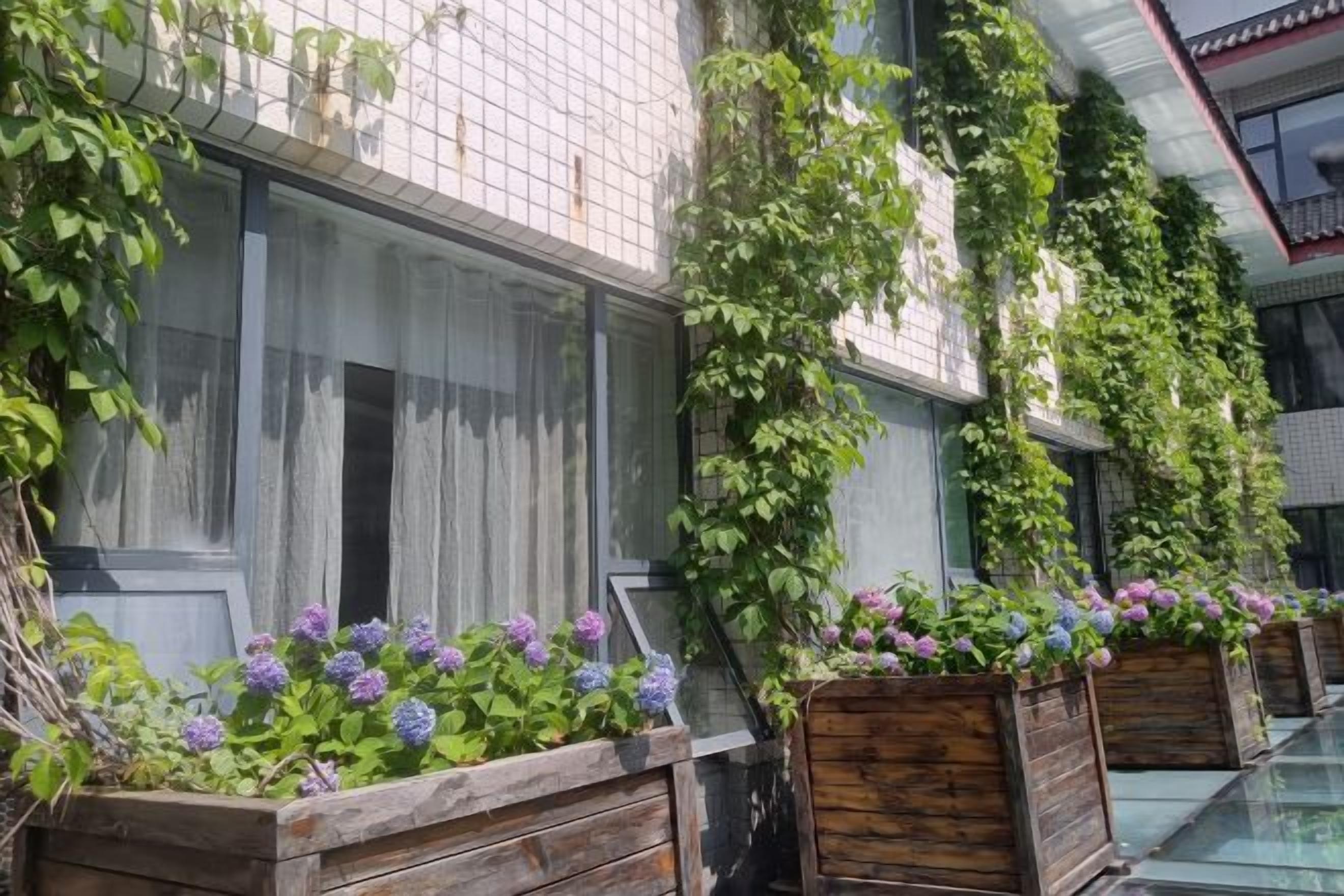 A building with vertical gardens and flower boxes along the exterior.
