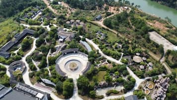 An aerial view of a landscaped area with pathways, a central circular feature, and surrounding greenery.