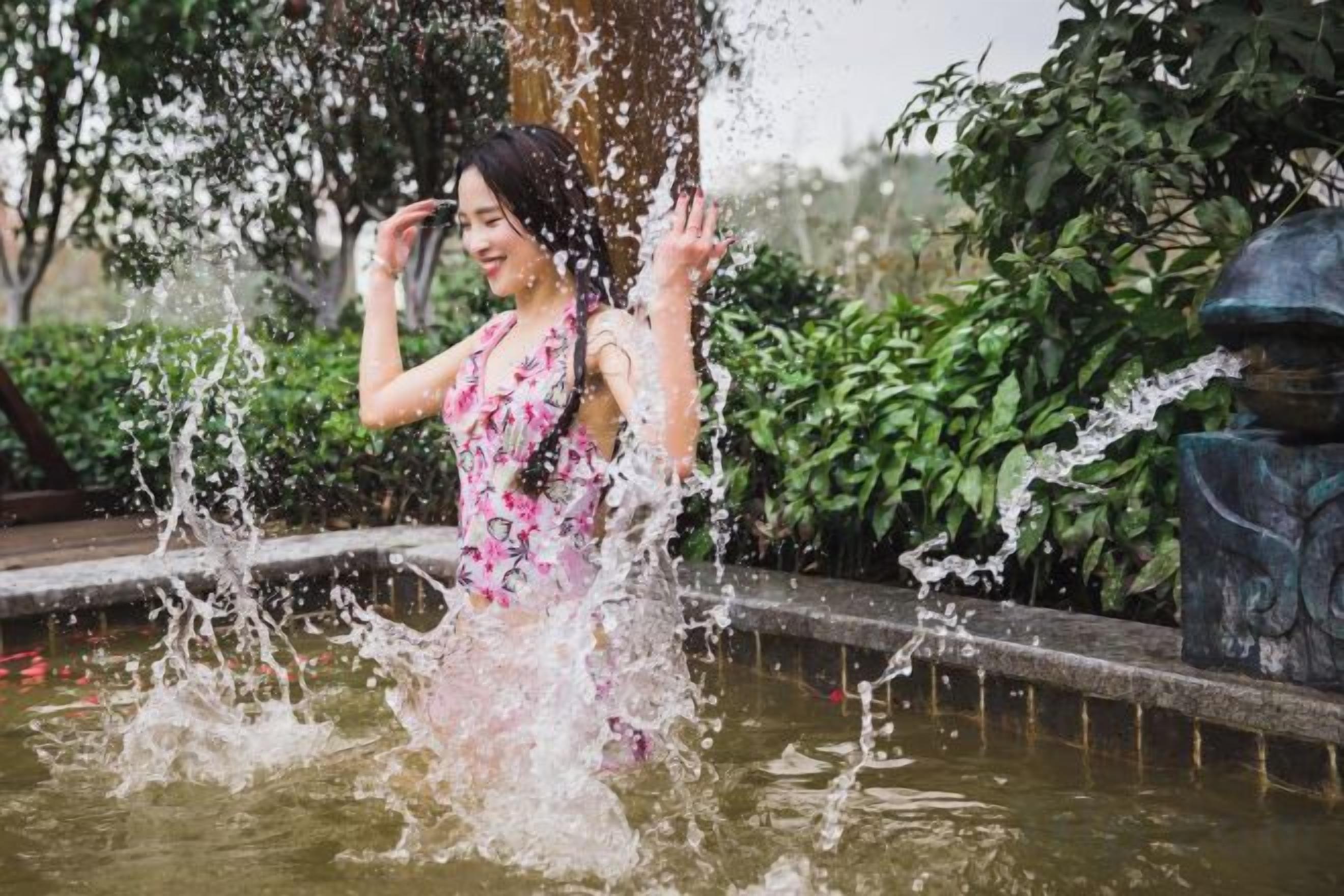 A person standing in a water feature with water splashing around them.