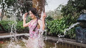 A person playing in a water feature surrounded by greenery. - Tangxi Hot Spring Resort (Chongren)