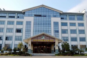 A modern building with a prominent entrance, large windows, and a symmetrical facade.