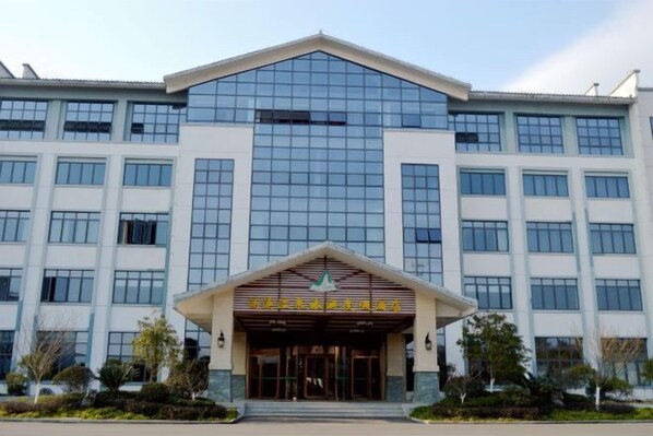 A modern building with a prominent entrance, large windows, and a symmetrical facade.