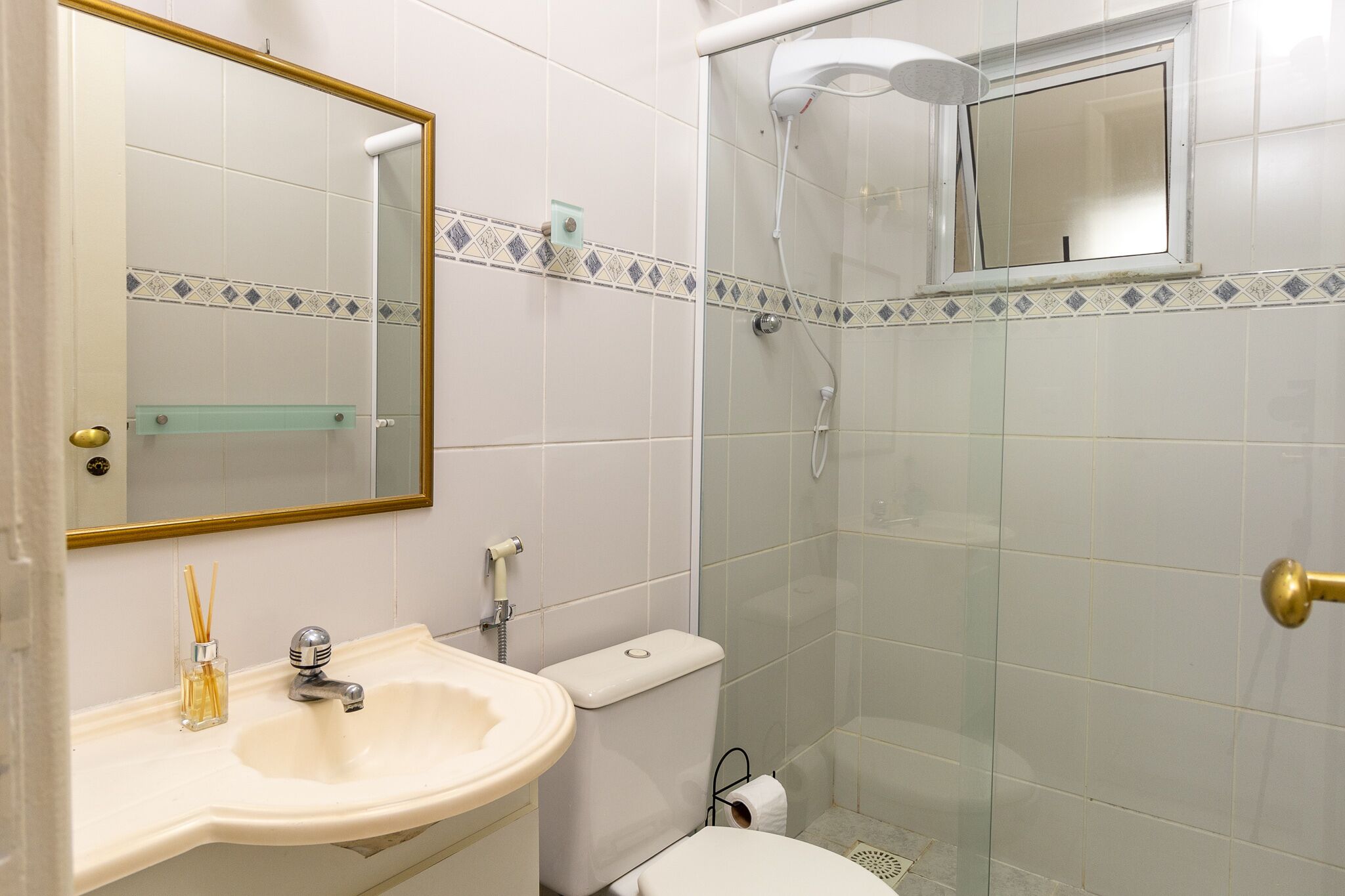 A bathroom with a sink, toilet, and glass-enclosed shower.
