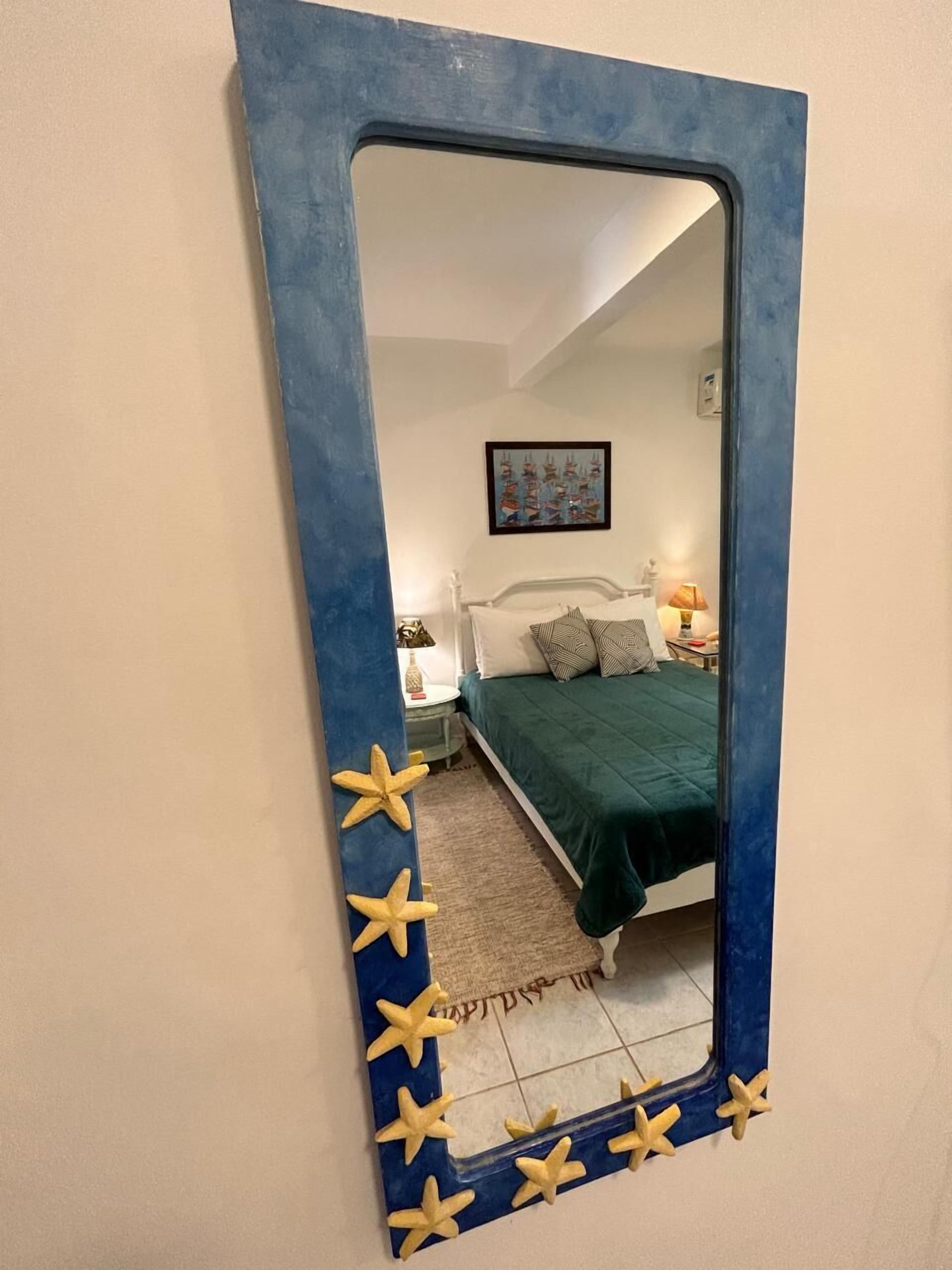 Une chambre à coucher avec un lit, une table de chevet, une lampe et un tableau encadré au mur.