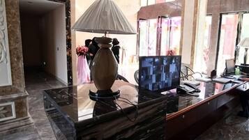 Ein Empfangsschalter mit einer Lampe, einem Computer und einer Blumenvase.