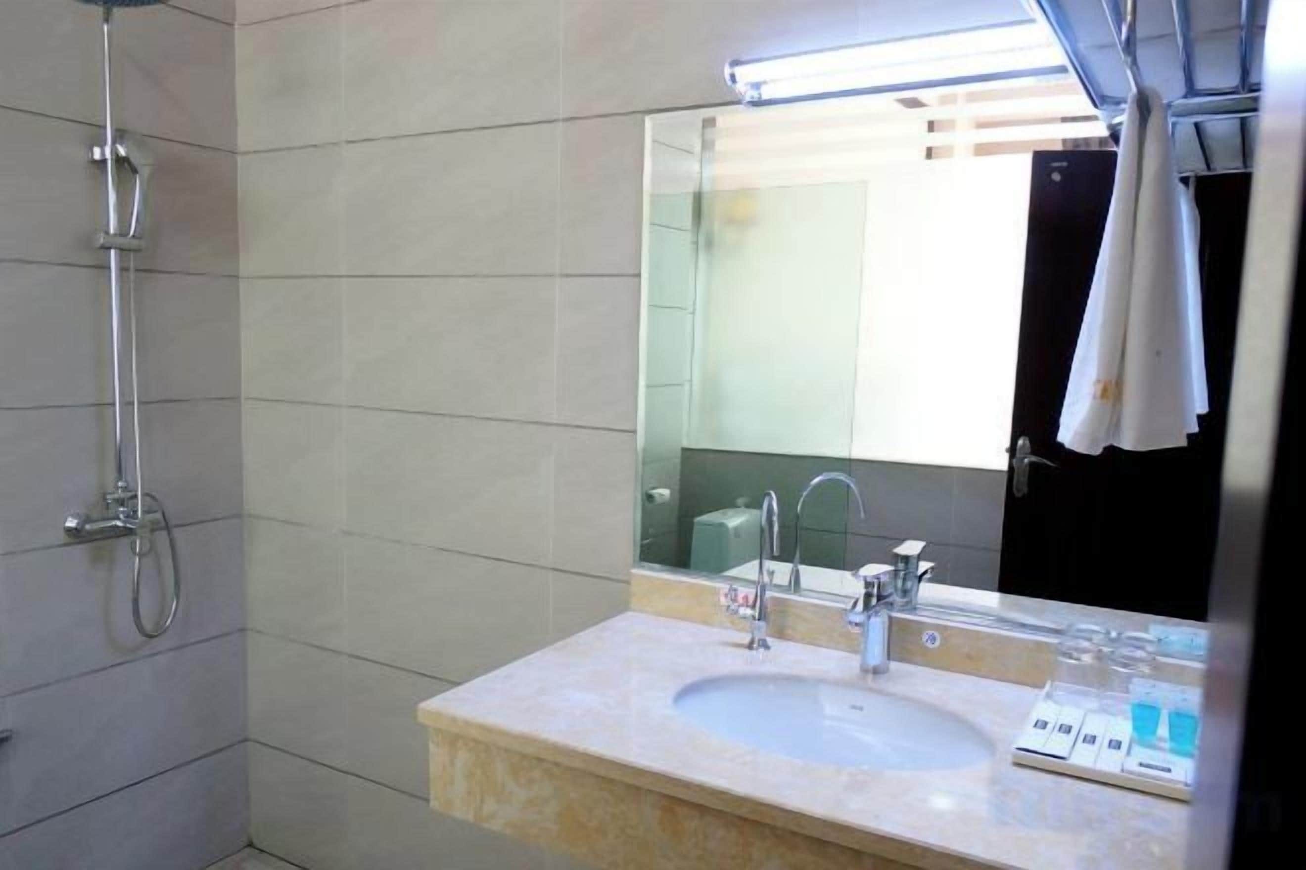 Un baño con lavamanos, espejo y ducha.