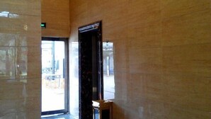 Un pasillo con paredes de piedra pulida y una puerta que da a un espacio exterior.