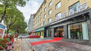 A hotel entrance with a red carpet leading to the door, a visible signboard, and a parked car. - Kaise Hotel (Lijiang Bailong Square Branch) (Lijiang)