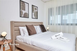 Relax in this inviting space with a comfortable bed, a side table, and artwork on the walls.