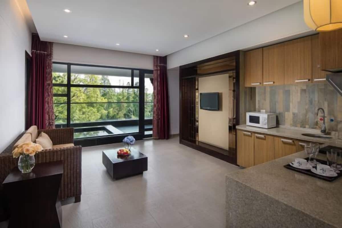 A modern living room with a sofa, coffee table, and a large window with curtains.