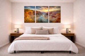 A bedroom with a large bed, two bedside tables with lamps, and a wall-mounted painting of a canyon. - Private Kierland Retreat, Gated Heated Pool, 400 sq ft Indoor Gym, Putting Green (Scottsdale)