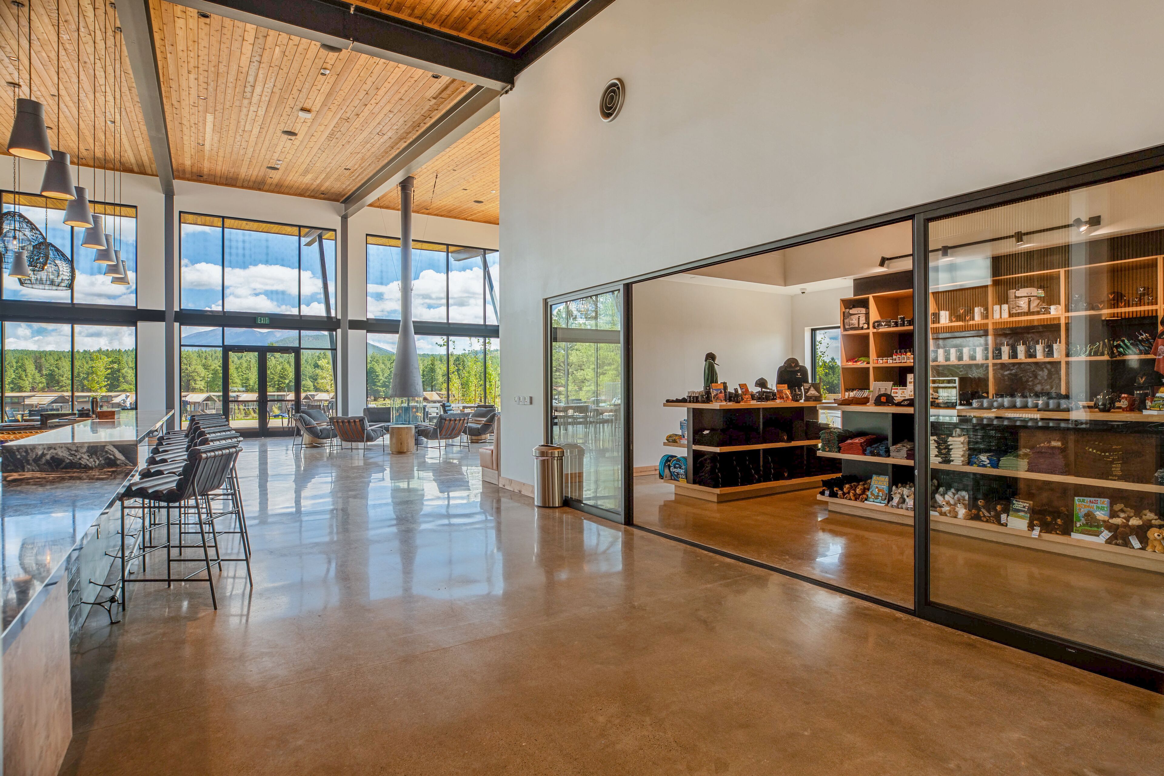 Un interior espacioso y moderno con una zona de bar, asientos y vistas al exterior.