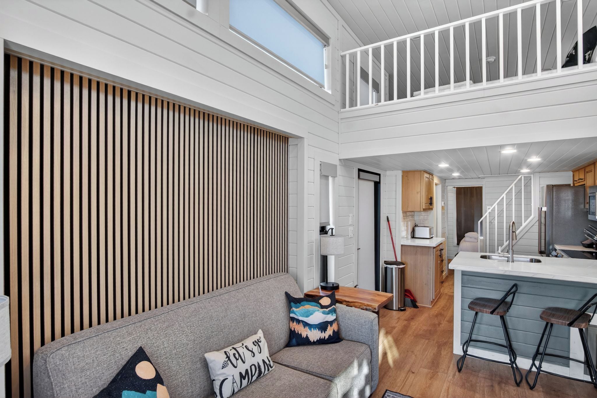 A modern interior with a loft-style living area, a kitchen, and a dining space.