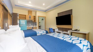 A hotel room with two beds, a kitchenette, a TV, and a desk. - La Vyoma Villas, Westpark Hwy 6 (Houston)