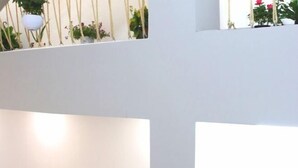 Interior com vários níveis, paredes brancas e corrimãos de madeira.