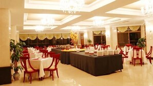 A banquet hall with tables set for dining, chandeliers, and potted plants. - Jinshuiwan Holiday Resort (Shucheng)