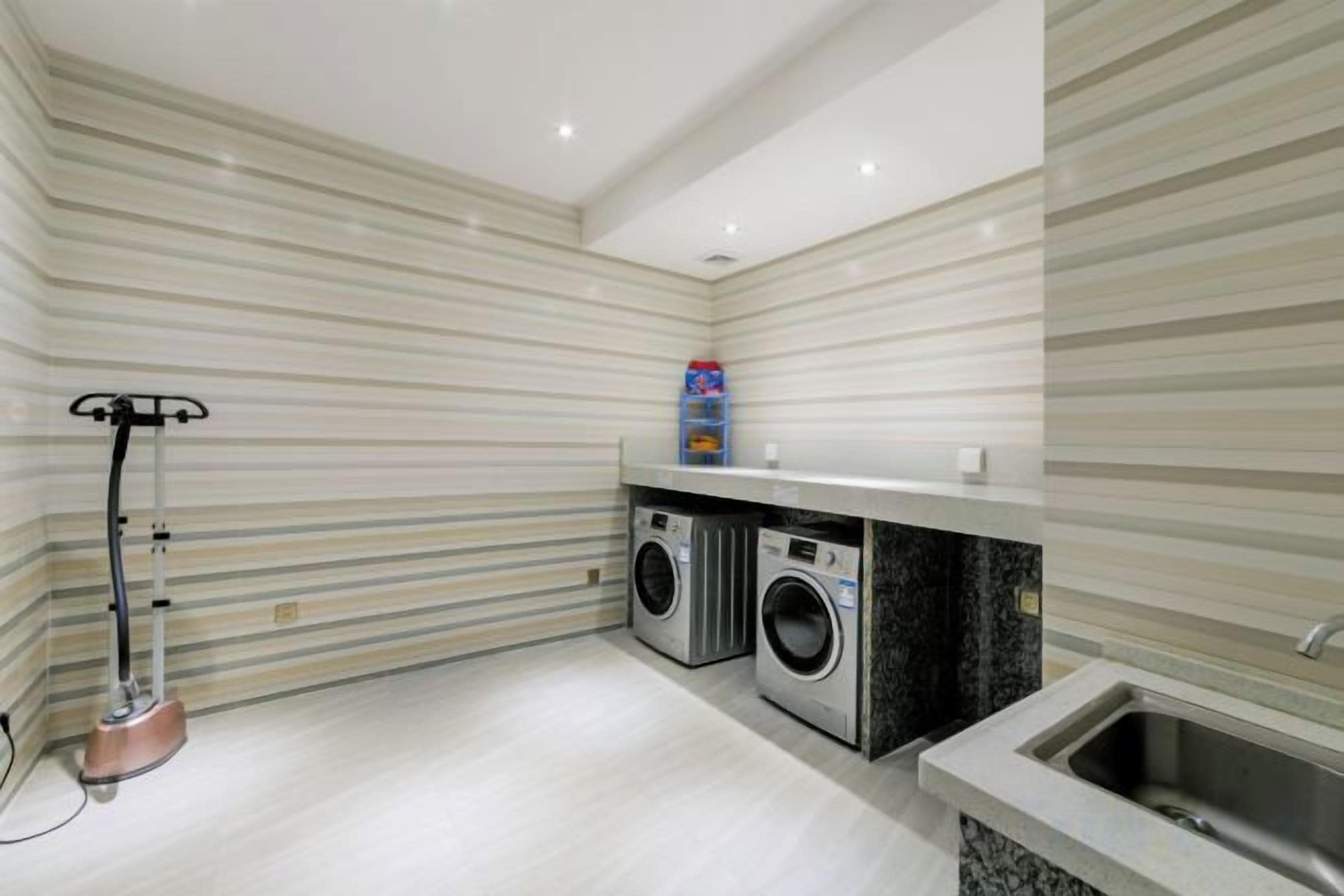 Un cuarto de lavandería con lavadora, secadora y un lavabo.