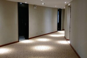 A hotel hallway with carpeted floors, a wooden baseboard, and a door at the end. - Superior Hotel (Ziyuan Bus Station) (Ziyuan)