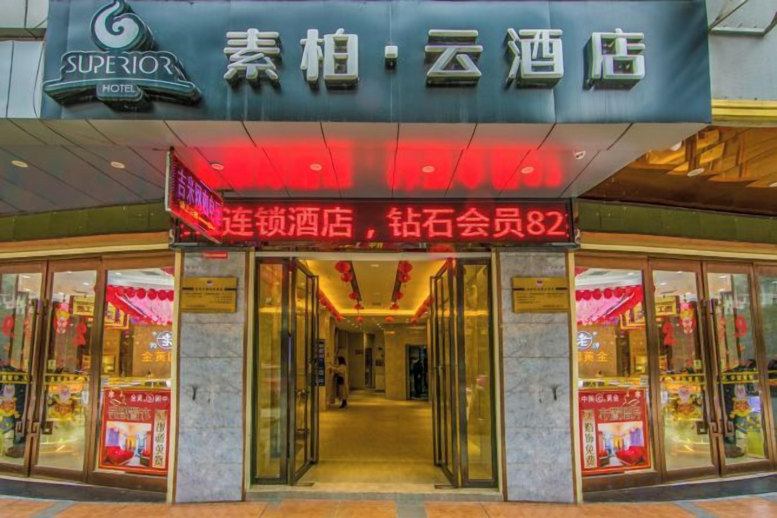 The entrance to a hotel with a prominent sign above the doors and a visible address number.