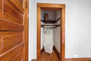 Staircase leads to an upper floor, with a door and a drying rack in the hallway.