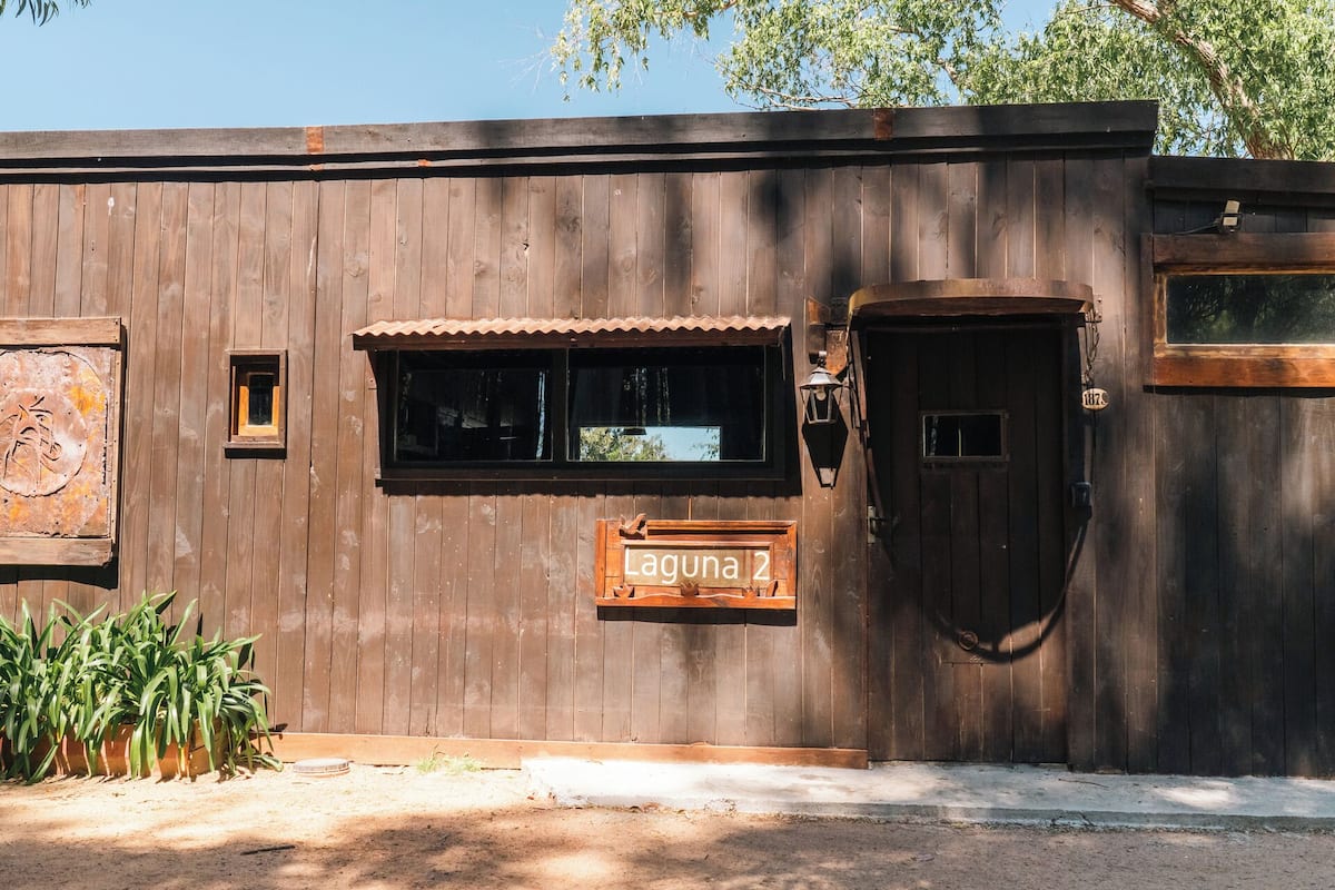 A wooden building with a sign reading "Laguna 2" and a door.