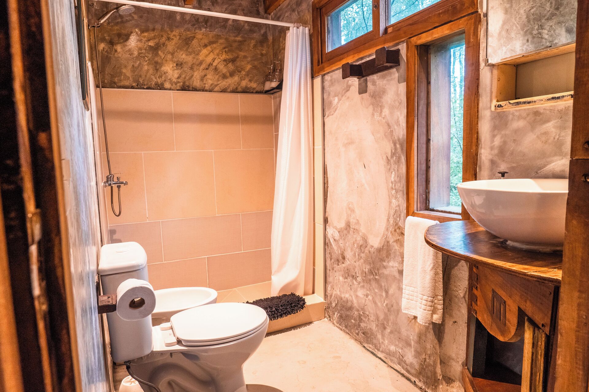 Un baño con inodoro, ducha y lavamanos.