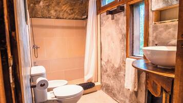 Un baño con inodoro, ducha y lavamanos.