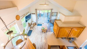 A compact, loft-style living space with a kitchen area, dining table, and seating area. - Beaver's Den: Private & Cozy Experience (Beaver)