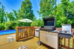 An outdoor deck with a grill, a small refrigerator, and a pool. - Browns Summit Vacation Rental w/ Fire Pit! (Browns Summit)