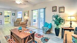 A spacious living room with a ceiling fan, a dining table, a sofa, and a large potted plant. - Venice Home w/ Private Pool, 7 Mi to Beach! (Venice)