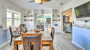 A spacious dining area with a wooden table and chairs, a ceiling fan, and a view into the adjacent living room. - Venice Home w/ Private Pool, 7 Mi to Beach! (Venice)