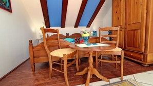 Ein gemütliches Zimmer mit einem hölzernen Bett, zwei Holzstühlen, einem kleinen runden Tisch und einem Holzschrank.