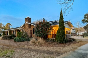 Stunning brick home with a modern design, featuring a prominent chimney and a beautifully maintained front yard.