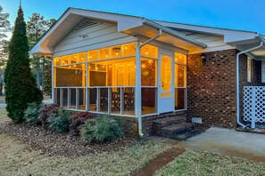 Relax on the enclosed porch with comfortable seating and enjoy the garden views.