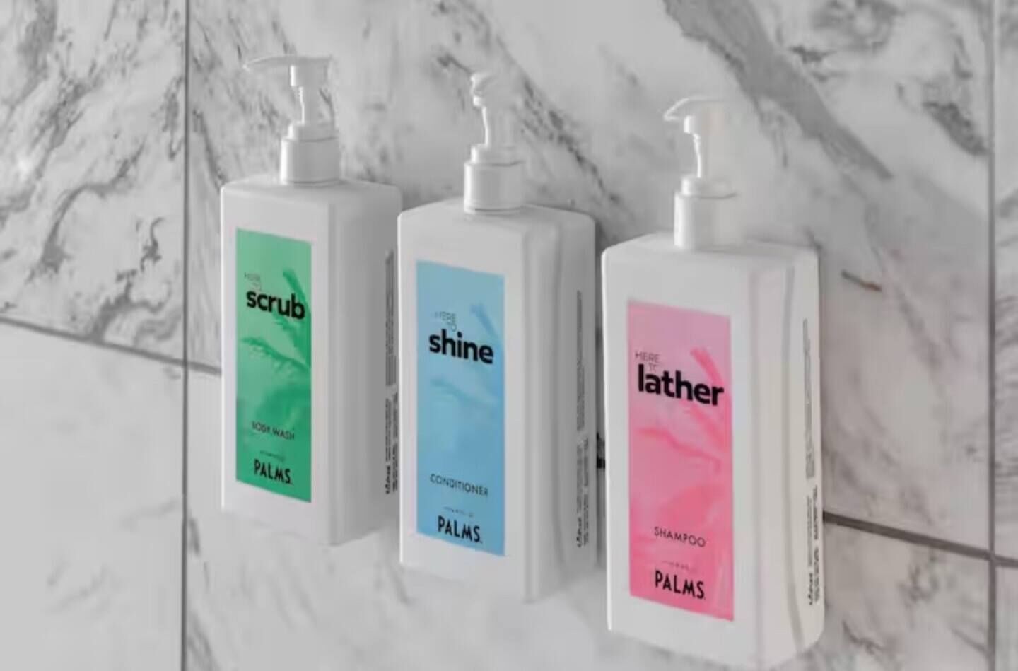 Three bottles of Palm's skincare products on a marble-tiled wall.