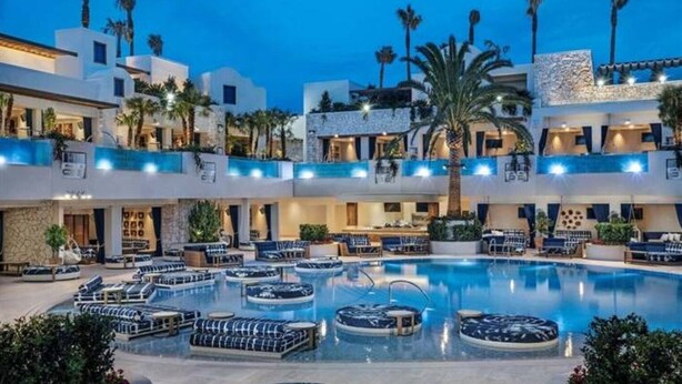 A hotel with a large indoor pool, multiple lounge areas, and a modern architectural design. - Luxe Condo l Balcony Strip View l NO RESORT FEES l FREE PARKING (Las Vegas)