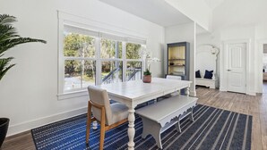 Une pièce spacieuse avec une grande fenêtre, une table à manger et un banc.