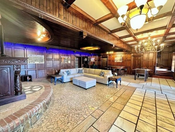 A spacious lobby with a large sectional sofa, a fireplace, and a chandelier.