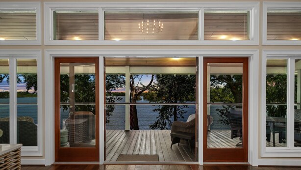 Un'ampia stanza con un'ampia porta-finestra che si apre su una terrazza con mobili da esterno.