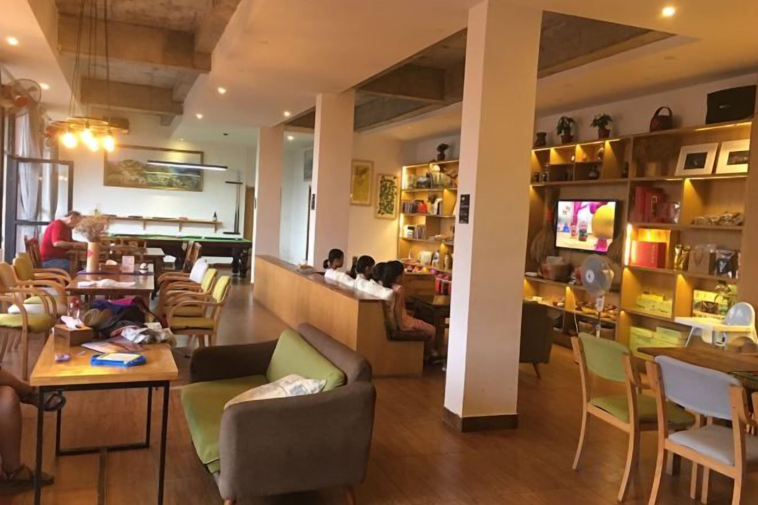 A restaurant with a bar area, seating arrangements, and a television screen.