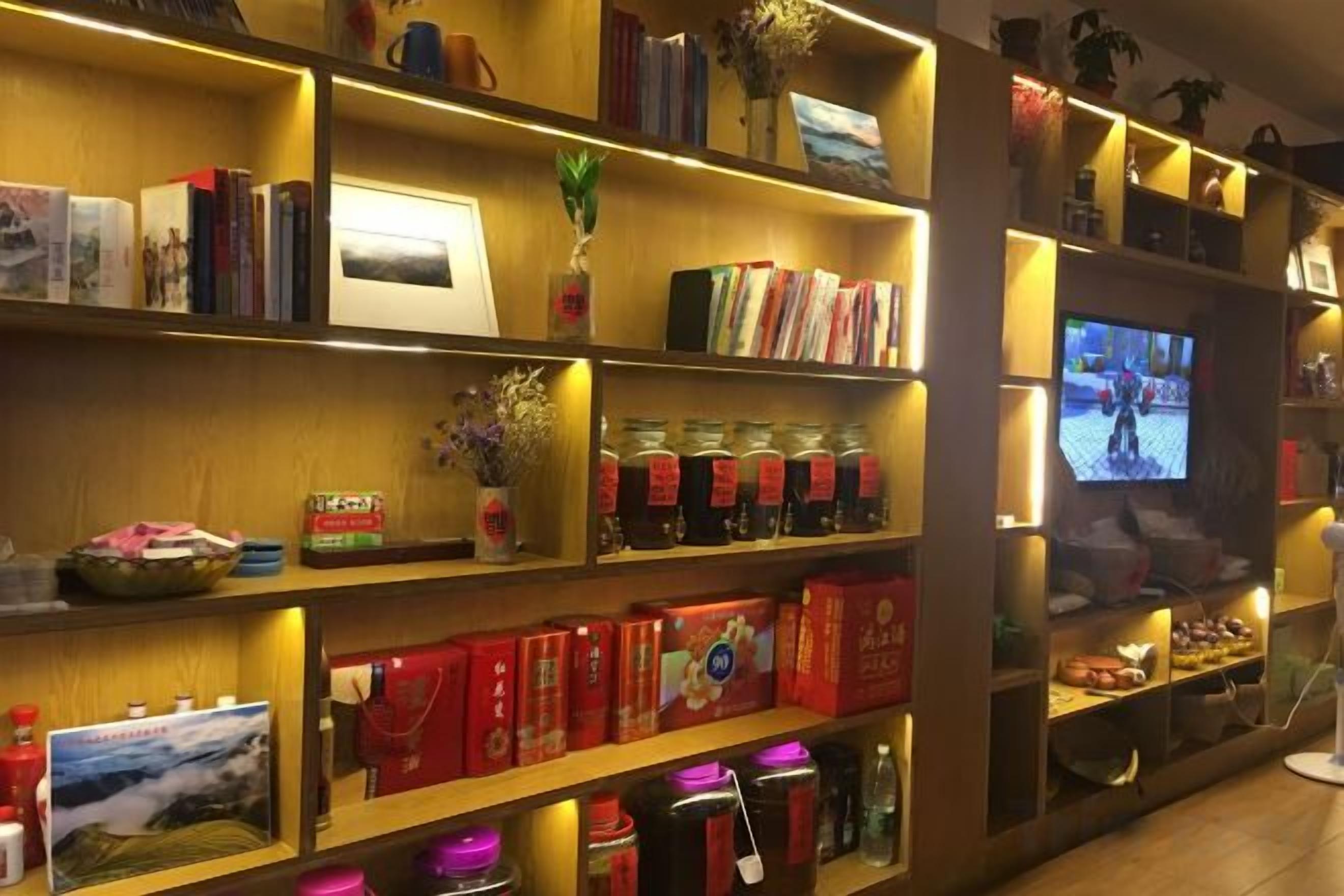 Habitación de hotel con una estantería, un televisor y diversos objetos decorativos.