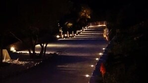 A nighttime pathway with steps leading to a building, illuminated by street lamps. - Tenuta Petra manna  (Palau)