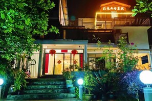 A hotel entrance with a staircase, illuminated by ground lights, and a sign above the door. - Yangshuo Moon Villa Homestay (Yulonghe Scenic Area Branch) (Yangshuo)