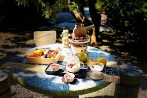 A round table with a variety of food items and a teapot, set outdoors with a natural backdrop. - Yangshuo Moon Villa Homestay (Yulonghe Scenic Area Branch) (Yangshuo)