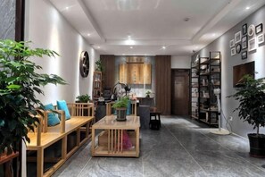 A modern living room with a sofa, coffee table, and potted plants. - Yangshuo Moon Villa Homestay (Yulonghe Scenic Area Branch) (Yangshuo)